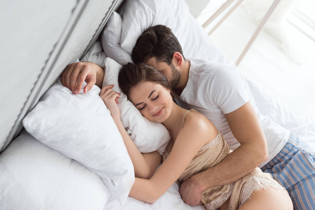 pareja abrazada en una cama